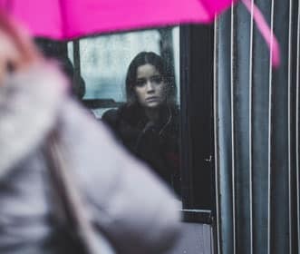 A woman looking out of a train looking pensive - Persons with ambivalent attachment needs emotional intimacy but they fear it.