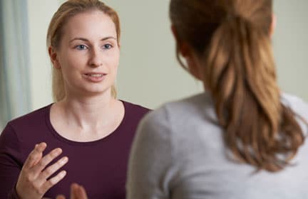 An image of a client talking to her counsellor shows their therapeutic relationship. The therapeutic relationship in counselling is how counsellors and clients connect with one another and build their relationship together.