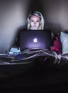 Disinhibition Effect in Online Therapy - a woman sitting in bed using her laptop